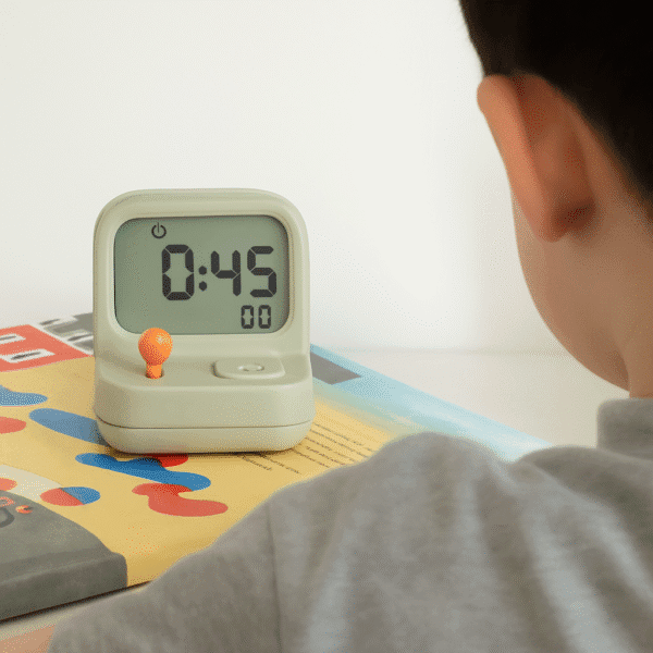 adfasdasd Réveil petit garçon posé sur un livre devant un enfant