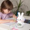 Réveil éducatif lapin devant une fille qui étudie