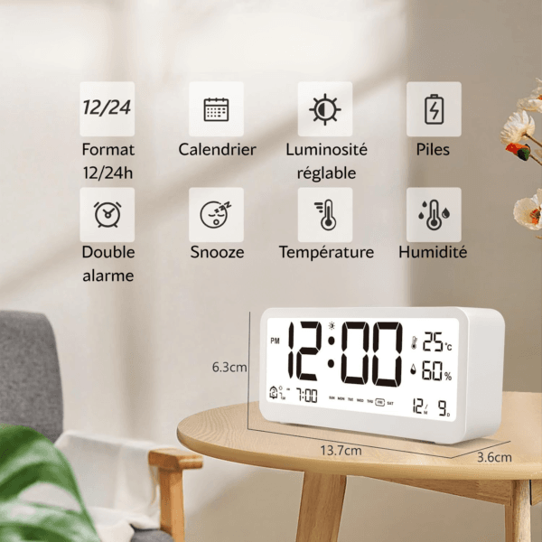 asnfjadjvnas Réveil blanc sur une table basse en bois avec ses fonctions en haut