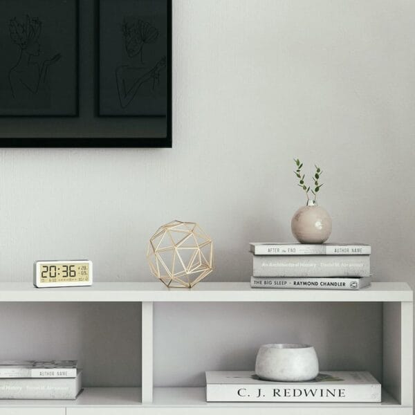 ehufayrgfyegr Réveil blanc sur un meuble dans un salon devant des livres