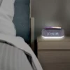 Réveil enceinte Bluetooth sur une table basse devant un lit