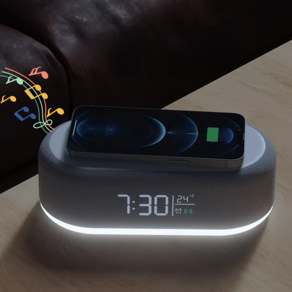 Réveil enceinte Bluetooth sur une table avec un smartphone qui charge au dessus