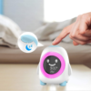 Réveil bébé jour nuit sur une table avec zoom sur le bouton snooze