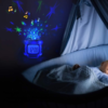 Réveil projecteur étoiles allumé devant un bébé qui dort